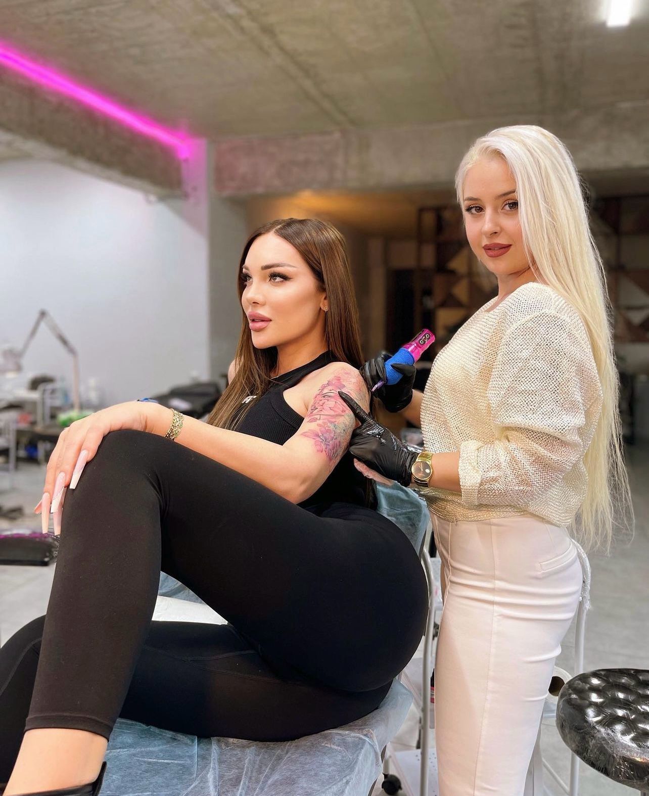 Tattoo artist working on client's arm
